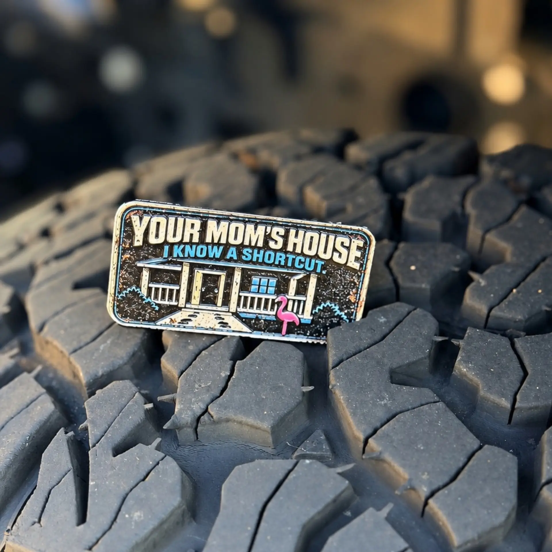 Your Mom's House trail badge photographed on a tire