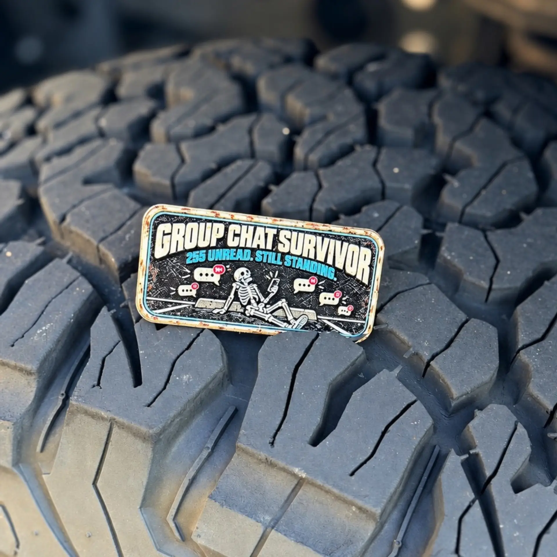 Group Chat Survivor trail badge photographed on a tire