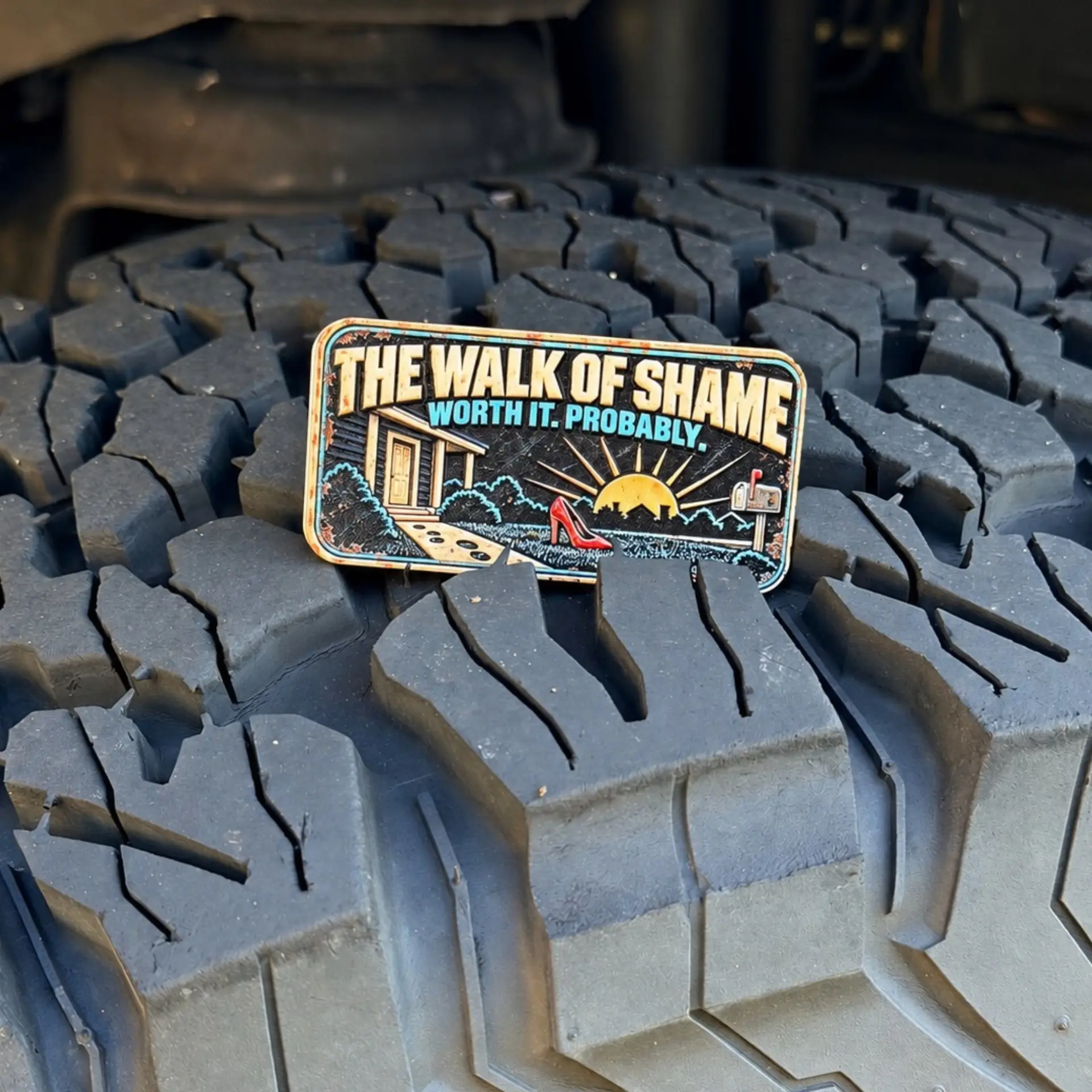 Walk of Shame trail badge photographed on a tire