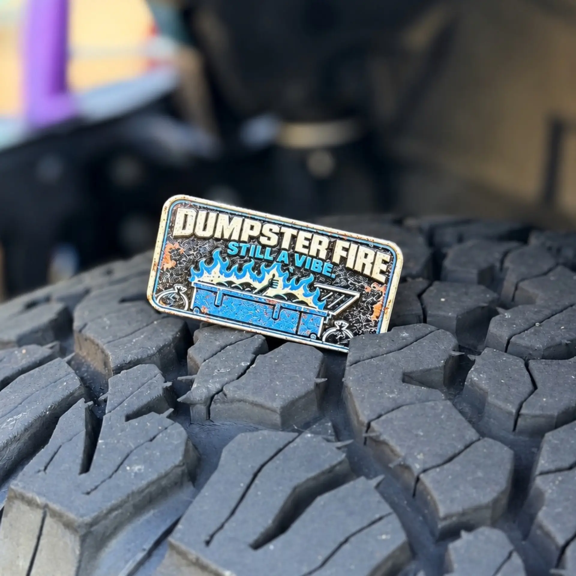 Dumpster Fire trail badge photographed on a tire